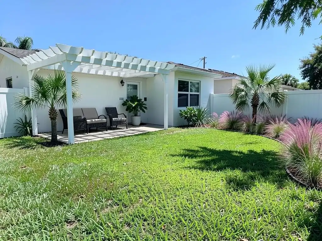 AI-edited version of the same image: a white wooden pergola over the patio with an outdoor sofa and two chairs under it, a palm beside the pergola and another at the right corner, and a curved bed of pink muhly grass along the right fence