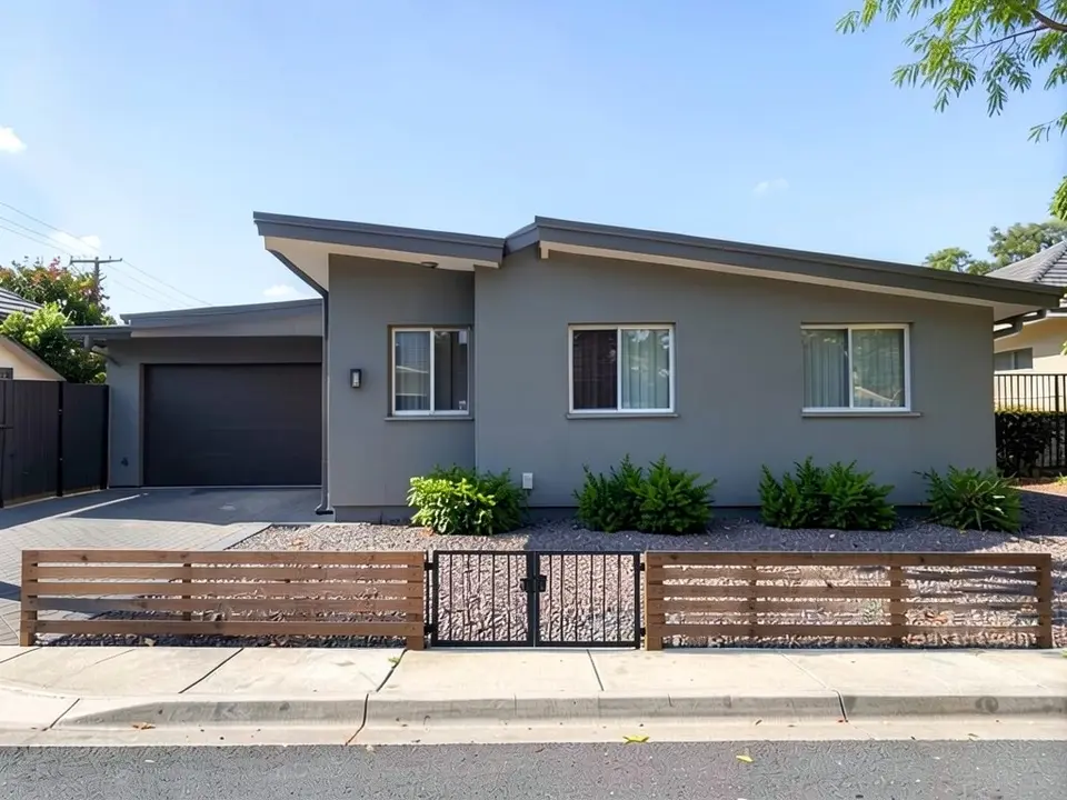 AI-edited version of the same image: a low horizontal wooden slat fence runs along the front of the gravel yard in two sections with a black metal gate between them