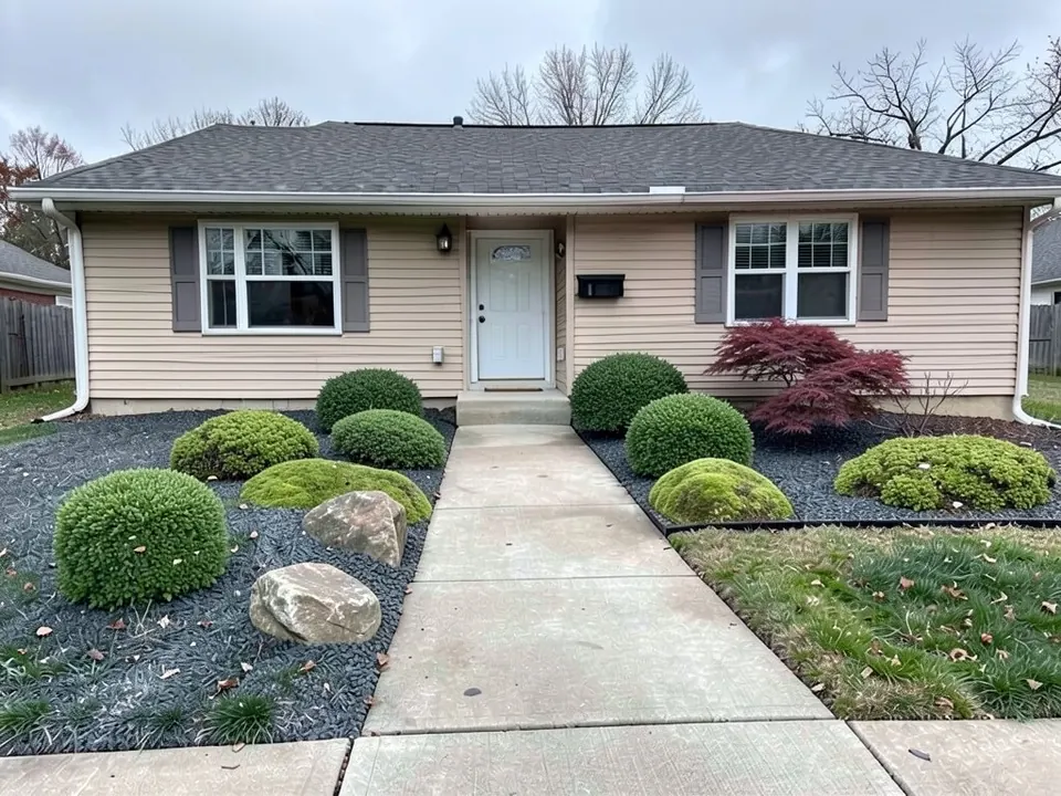 AI-edited version of the same image: the beds along the house covered with dark gray gravel and planted with clipped round evergreen shrubs, low mounds of moss, two boulders and a red-leaf Japanese maple under the right-hand window